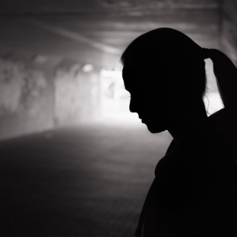 Schwarz weiß Schattenumriss von Frau in dunklem Tunnel