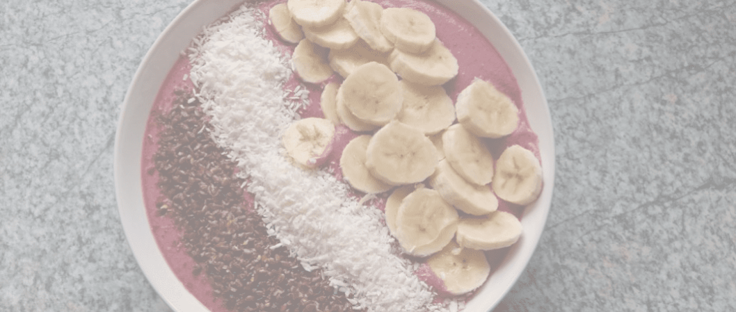 Gesunde rote Bowl mit Kokos, Bananen und Leinsamen
